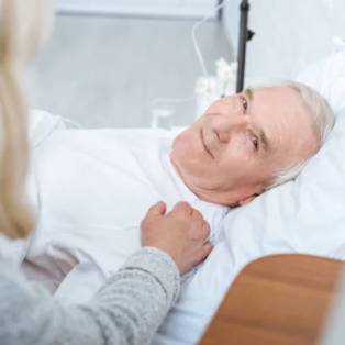 hombre mayor sonriente en la cama de un hospital