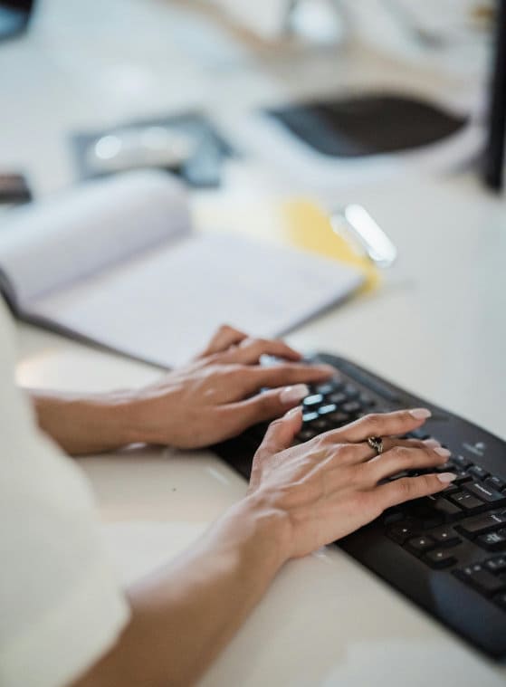 manos de mujer en un teclado de ordenador