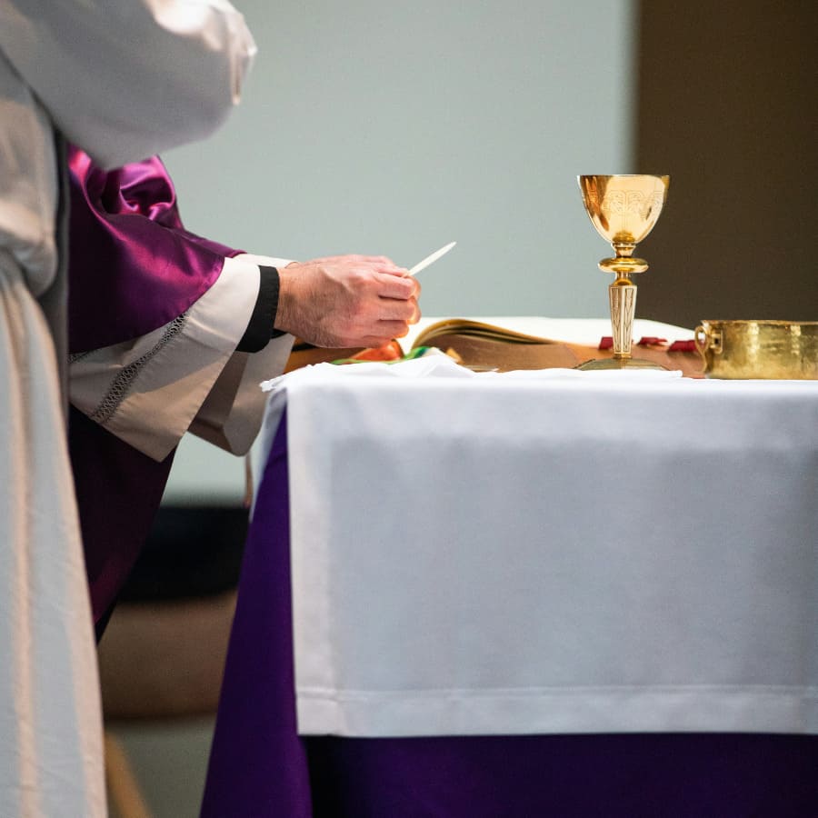 manos de un sacerdote bendiciendo la hostia de comunión en el altar